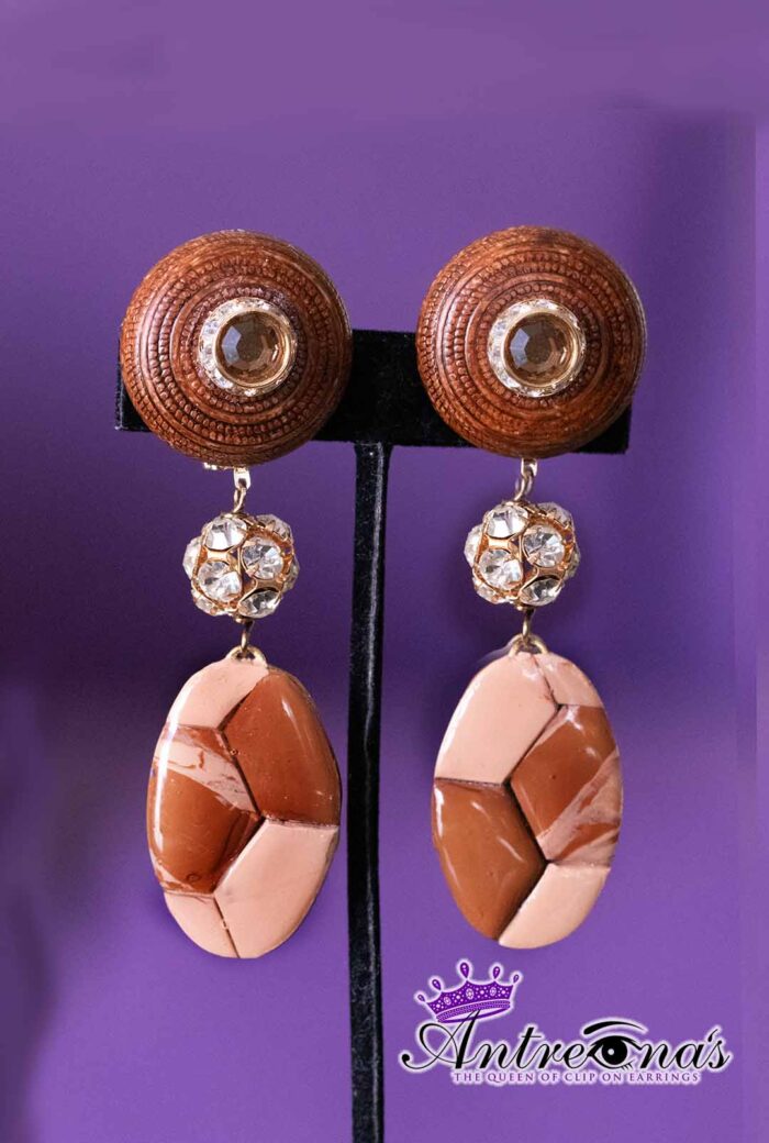 These clip-on earrings combine warm earthy tones with subtle sparkle, creating a quiet yet commanding presence.